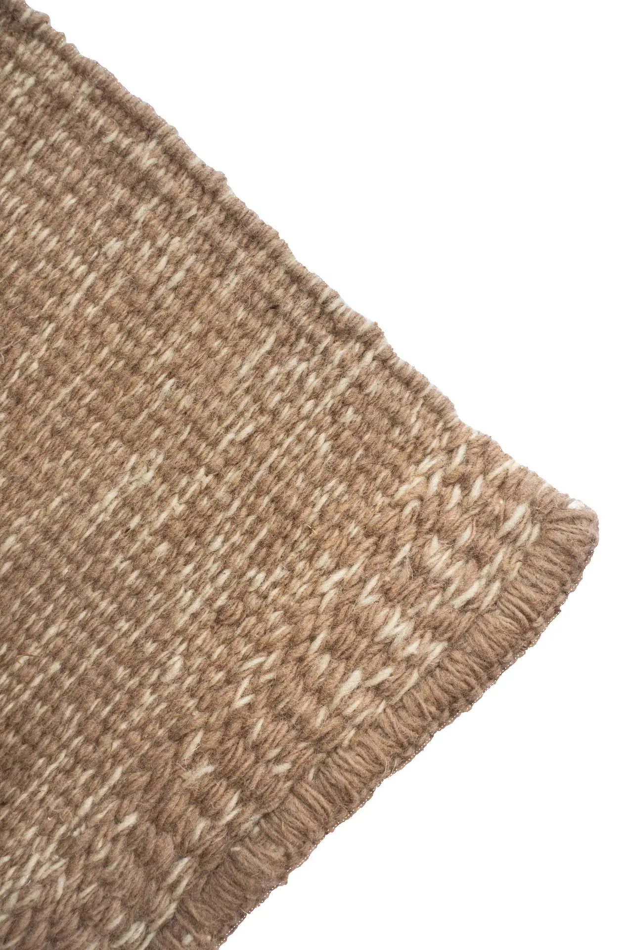 Corner detail of a Mono rug, showing the twining border and double-scale surface texture in tan mixed with white wool. By Thurje Handmade, Korça, Albania.